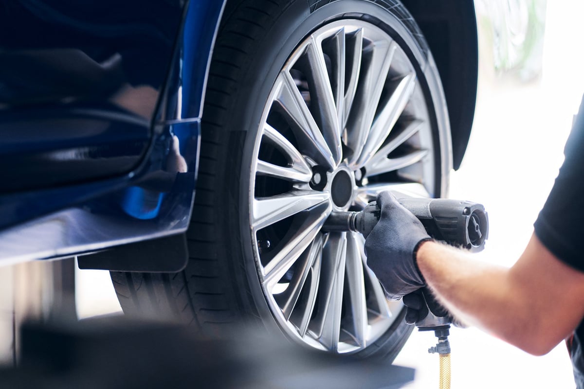 Mechanic changing a car wheel in the X3M Auto Care service bay